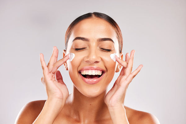 Mujer aplicando crema en el rostro
