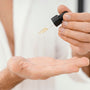 Persona poniendose serum facial en la palma de la mano