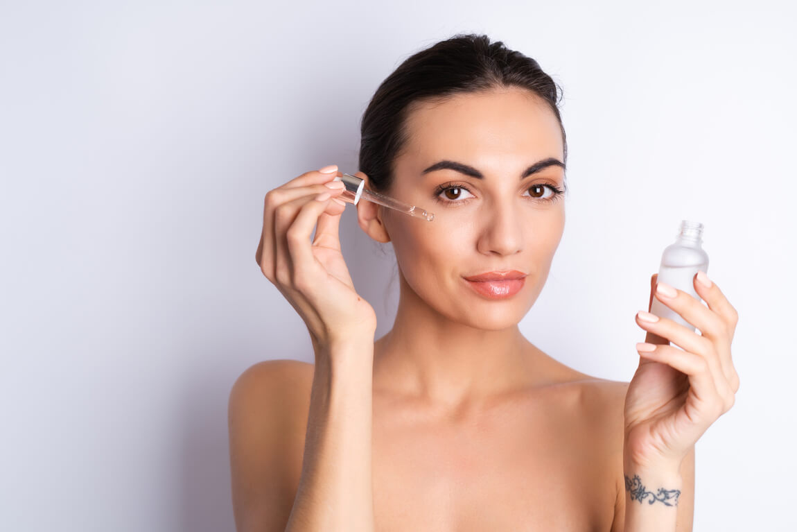 Mujer aplicandose tonico facial en el rostro